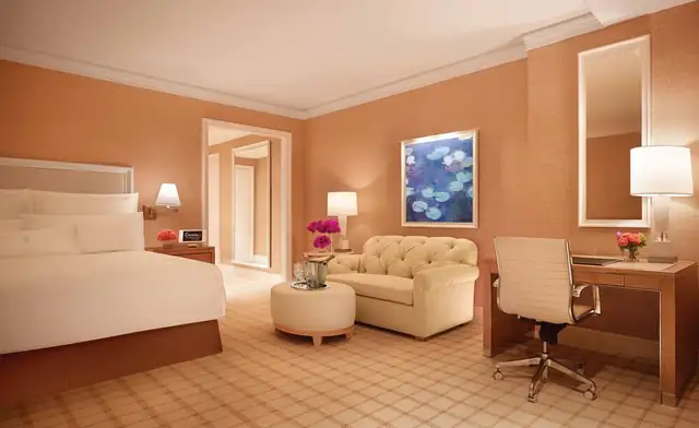 Encore Boston Harbor à Everett, chambre avec grand lit et fauteuil avec pouf