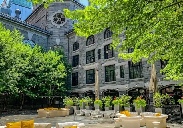 The Liberty à Boston, espace extérieur avec chaises blanches et jaunes entre les arbres