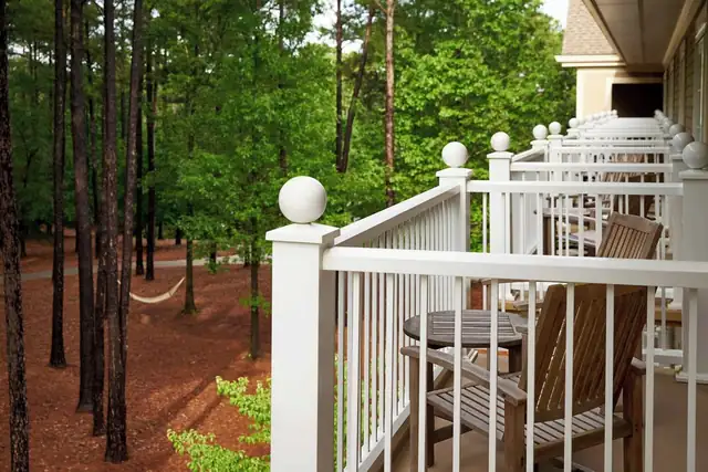 The Ritz-Carlton Reynolds à Greensboro, terrasse en bois aux gardes-corps blancs et table